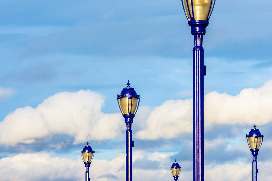 lightposts against blue sky and clouds